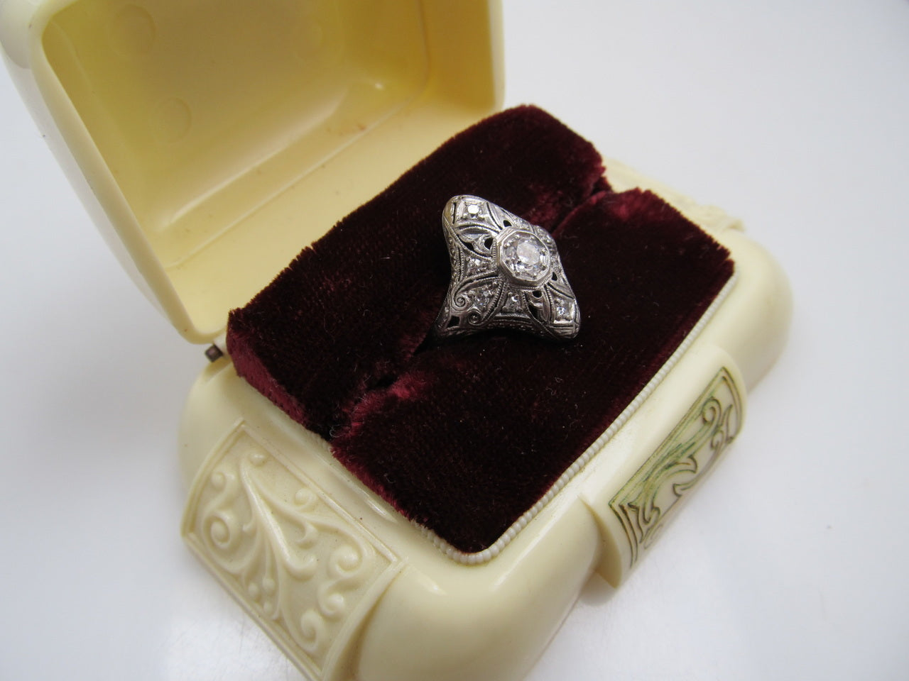 19k white gold filigree ring with a .25ct center OEC diamond.   Circa 1920.