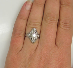 19k white gold filigree ring with a .25ct center OEC diamond.   Circa 1920.