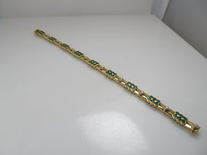 14k yellow gold line bracelet with emeralds and diamonds