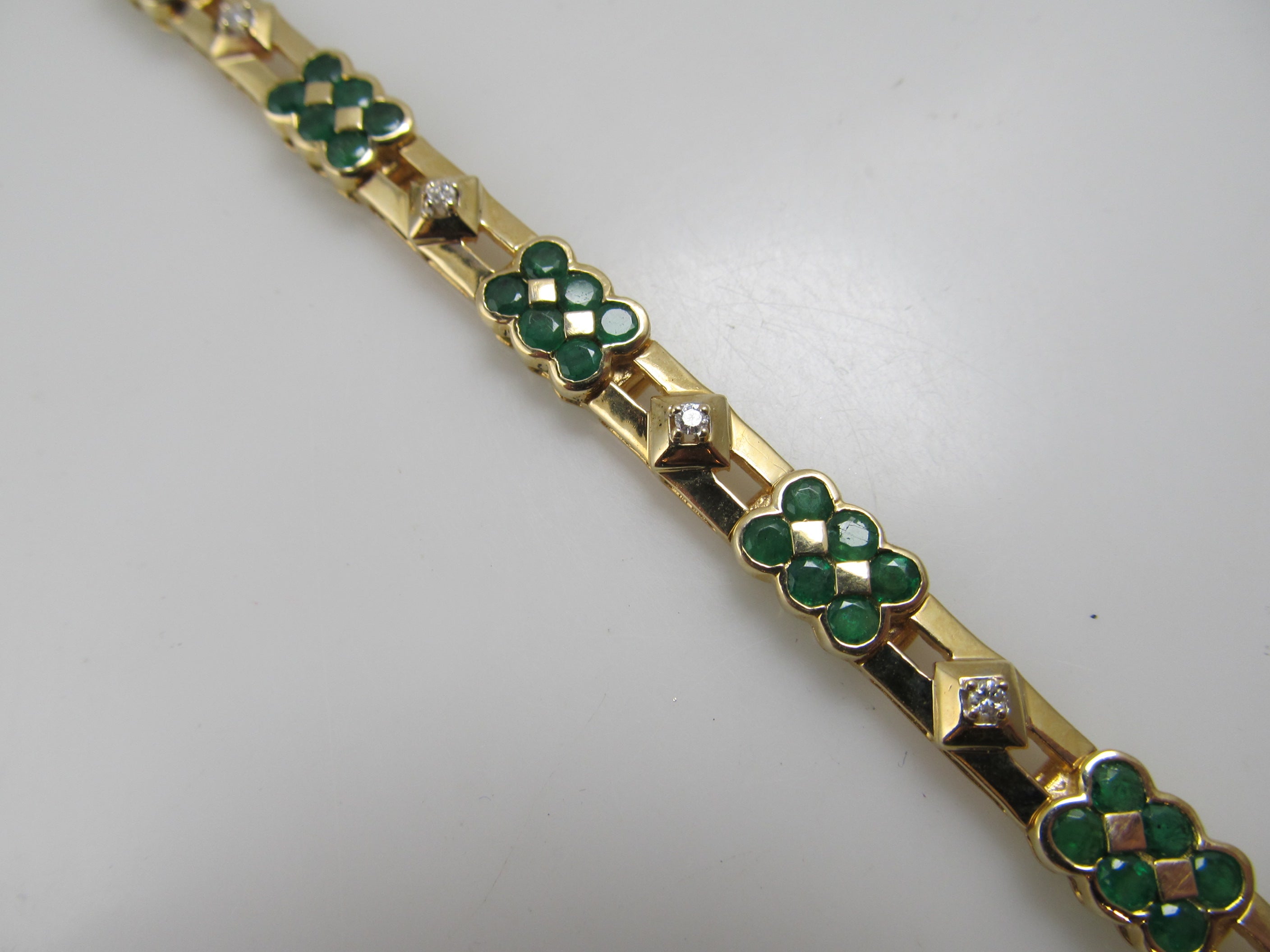 14k yellow gold line bracelet with emeralds and diamonds