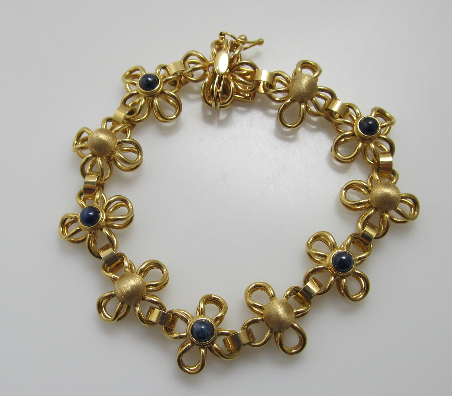 Yellow gold flower bracelet with cabochon sapphires