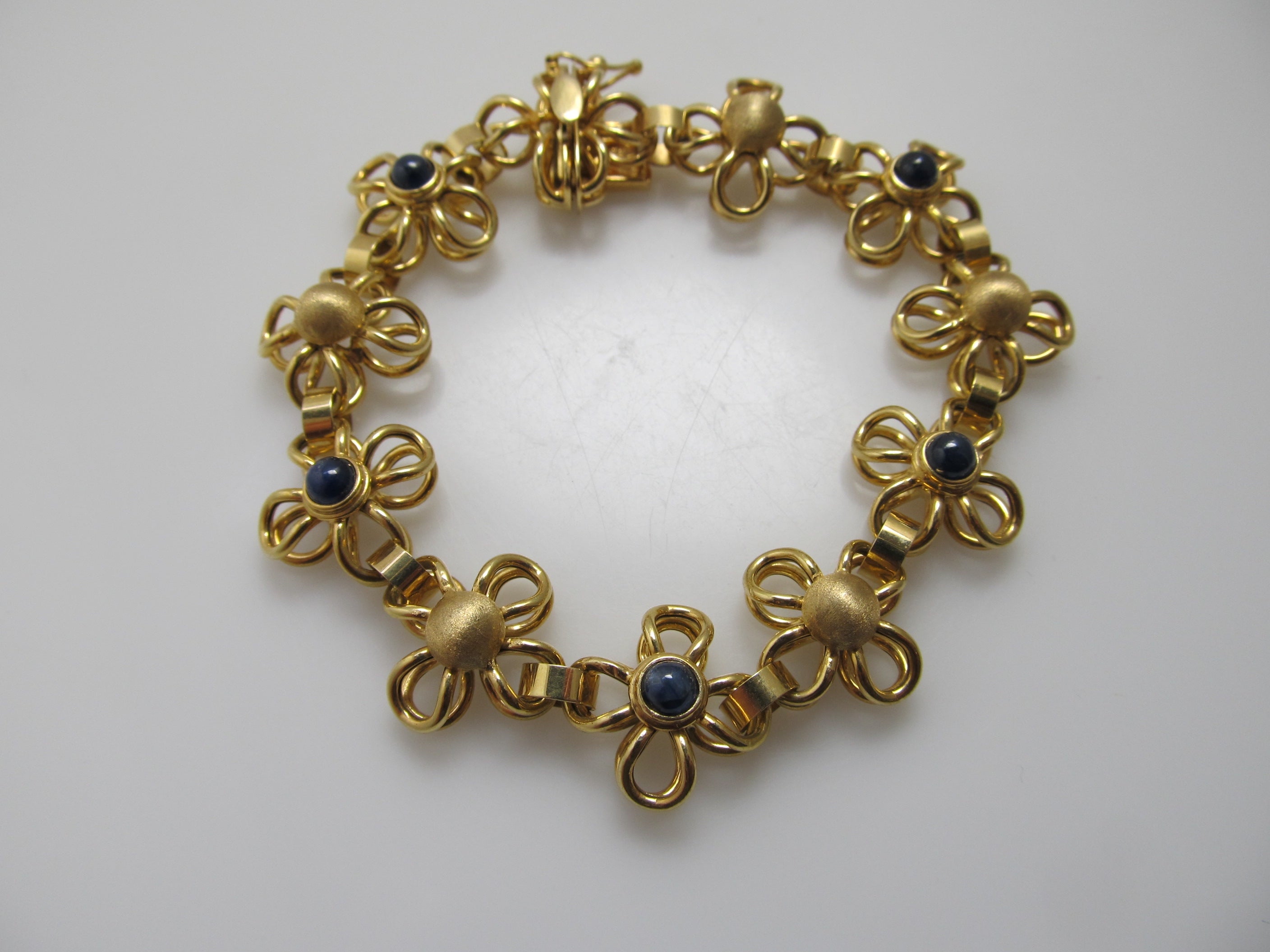 Yellow gold flower bracelet with cabochon sapphires