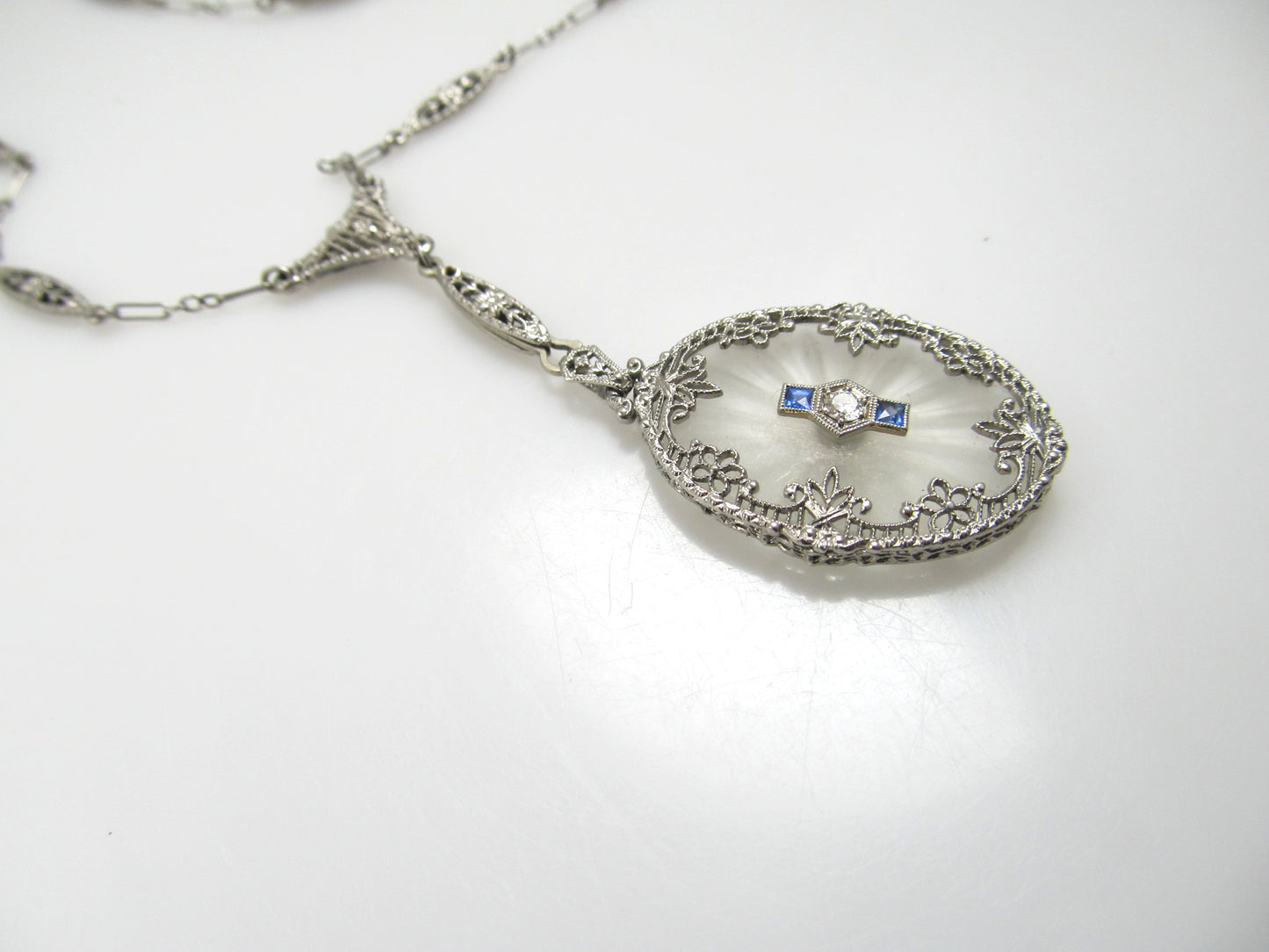 14k White Gold Filigree Necklace With A Diamond, Sapphires And Camphor Glass, Circa 1920