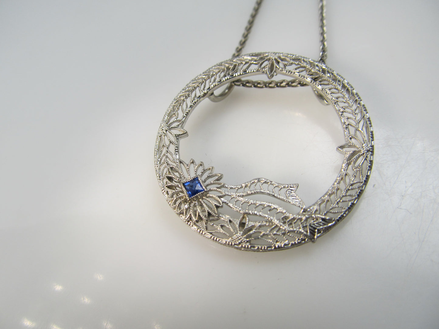 14k white gold filigree circle necklace with a sapphire, circa 1920