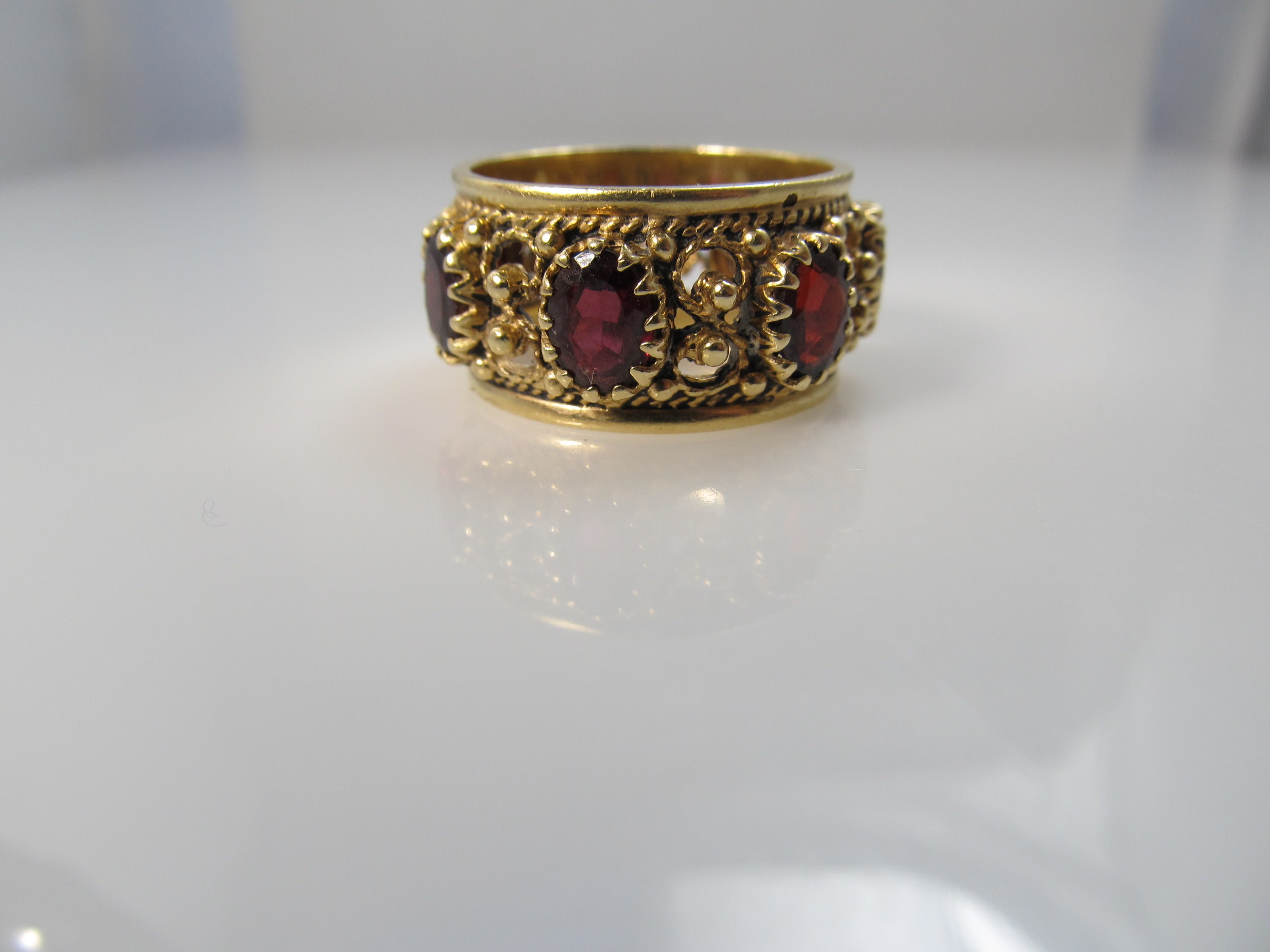 Wide garnet eternity band in 14k yellow gold, size 9 1/2