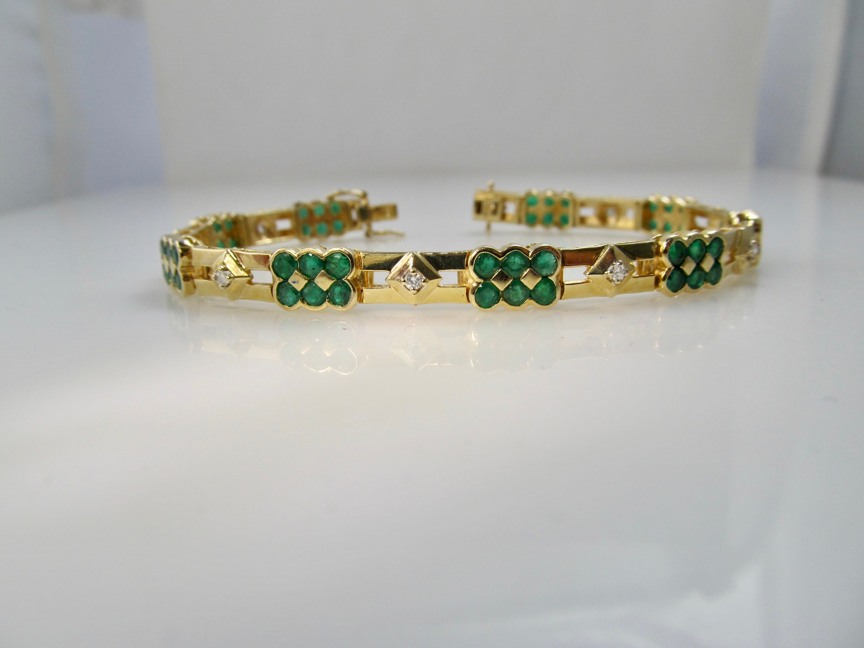 14k yellow gold line bracelet with emeralds and diamonds